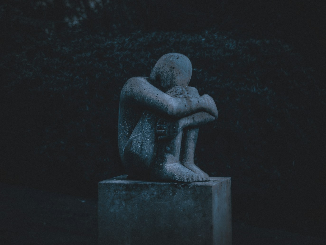 Person sitting alone in a dark room experiencing depression