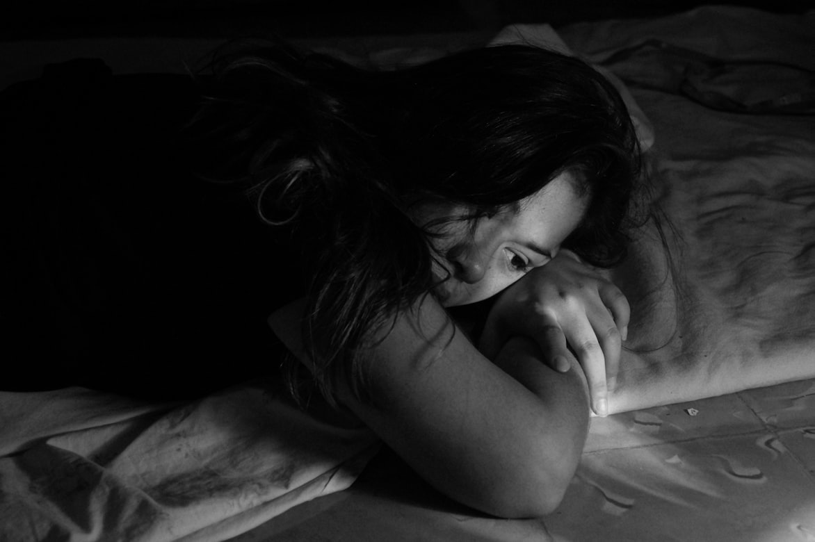 Person lying awake in bed at night unable to sleep due to medication side effects